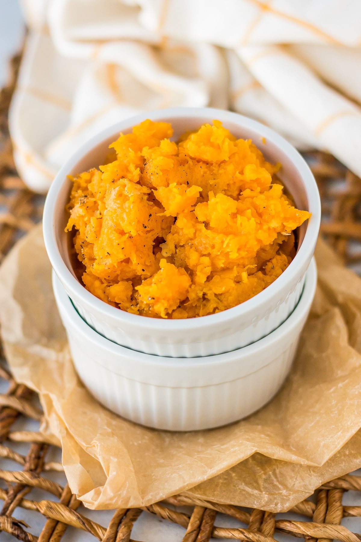 butternut squash puree served with salt and pepper in a white ramekin.