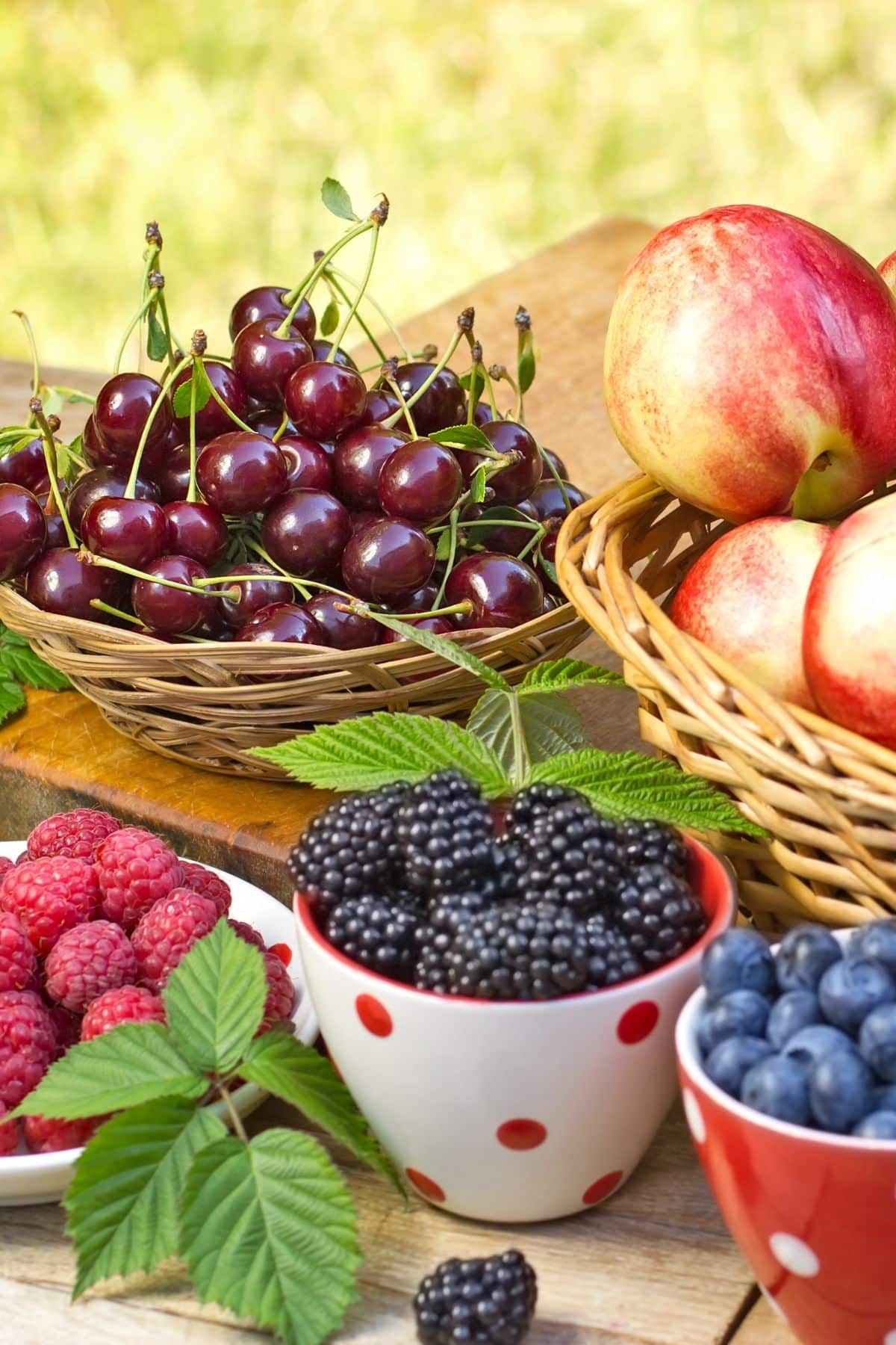 berries and cherries on a table outside.