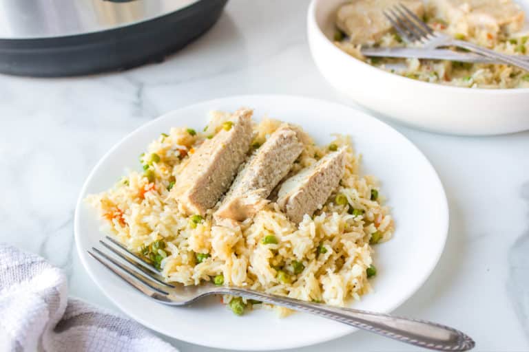 plate with instant pot sliced pork chops and rice with a fork