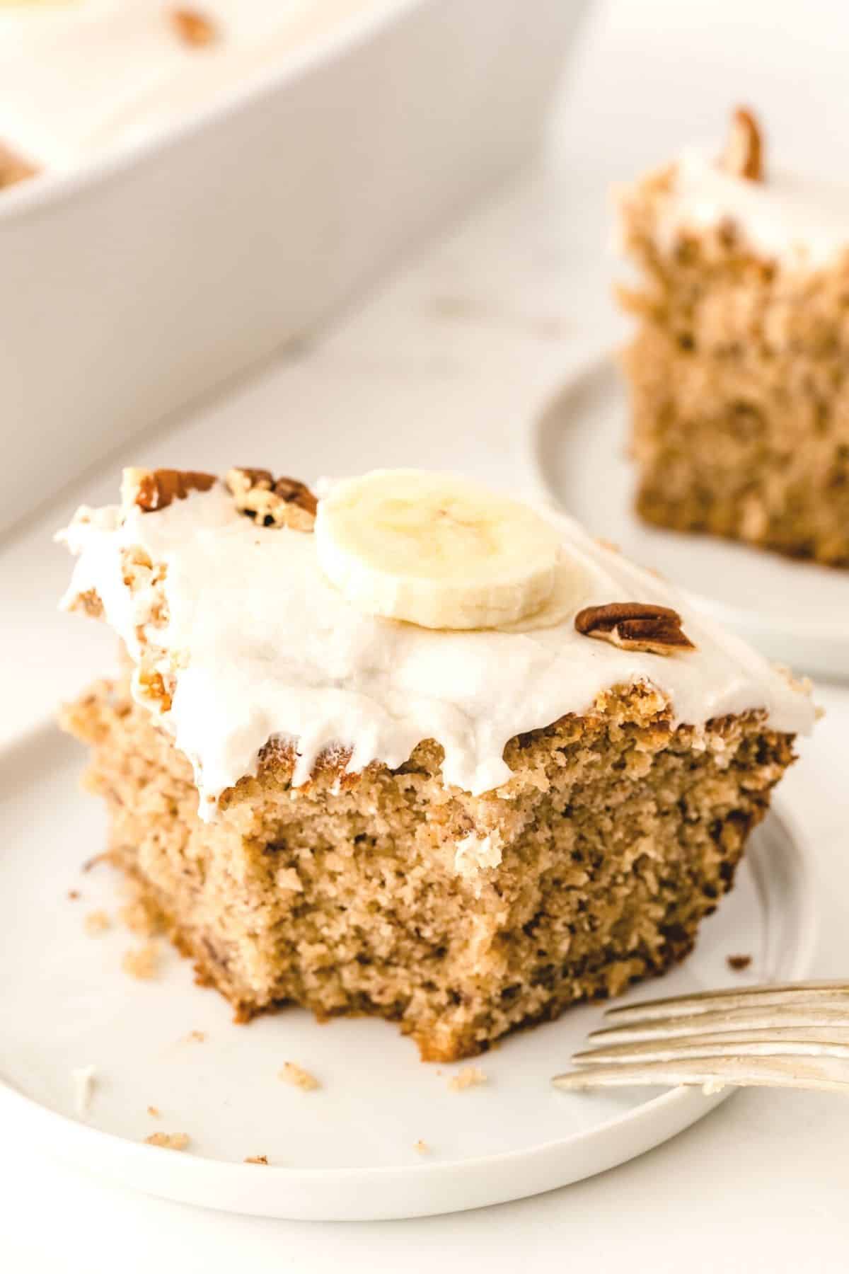 A slice of gluten-free and dairy-free banana cake on a white plate with fork.