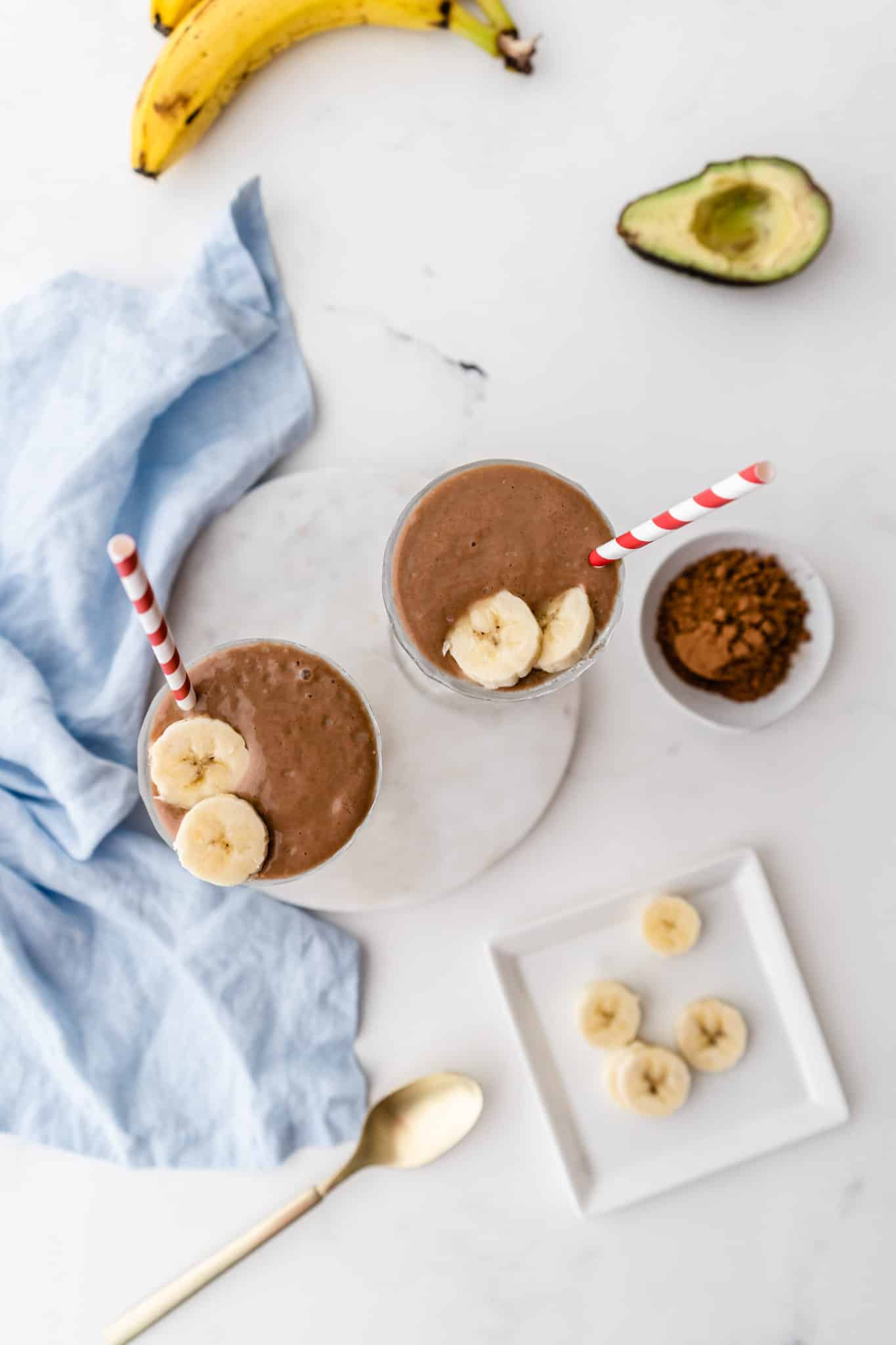 avocado smoothie with ingredients on a table.