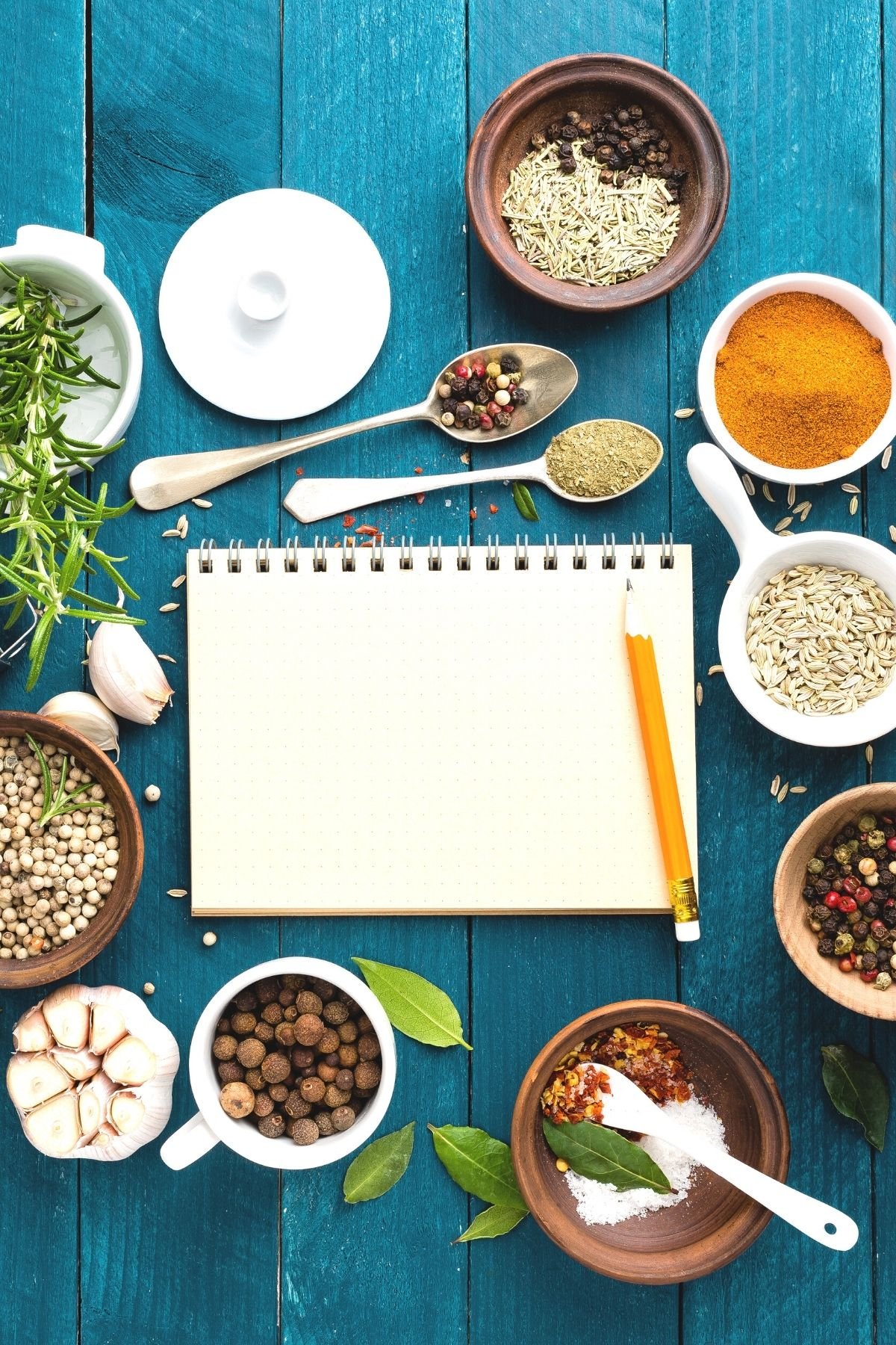 blank journal on a table surrounded by spices.