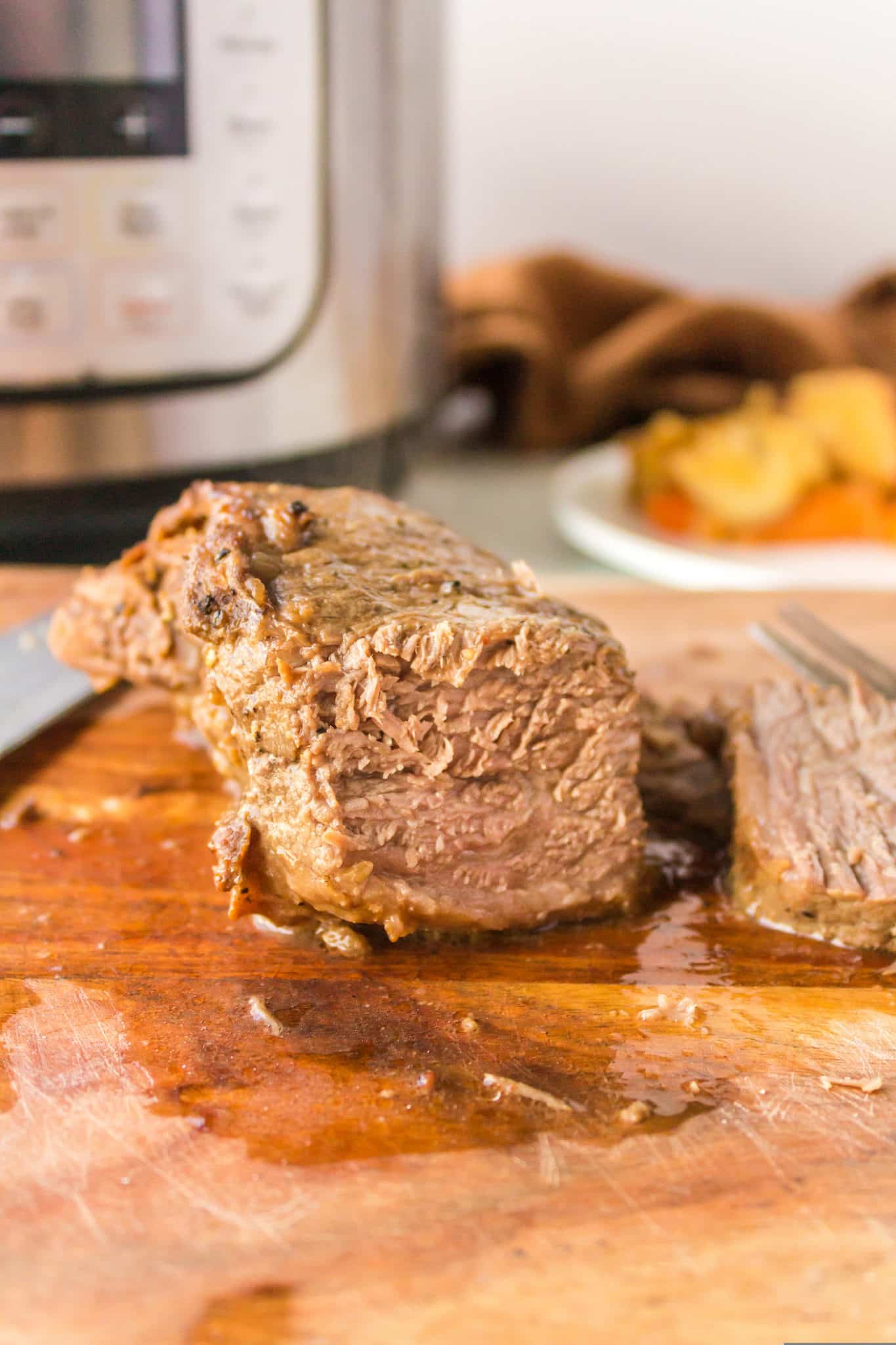 cooked tri tip roast on a cutting board.