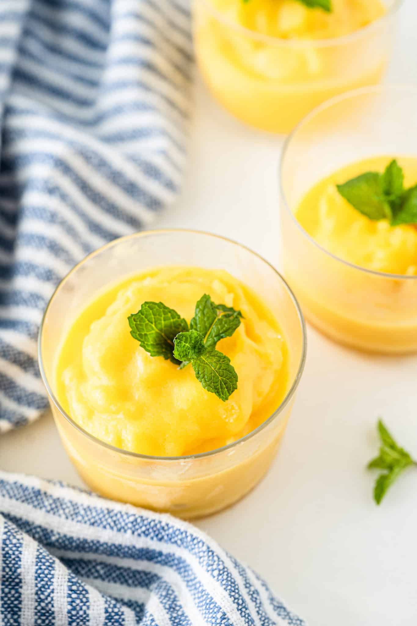 cups of mango sorbet made in a blender.