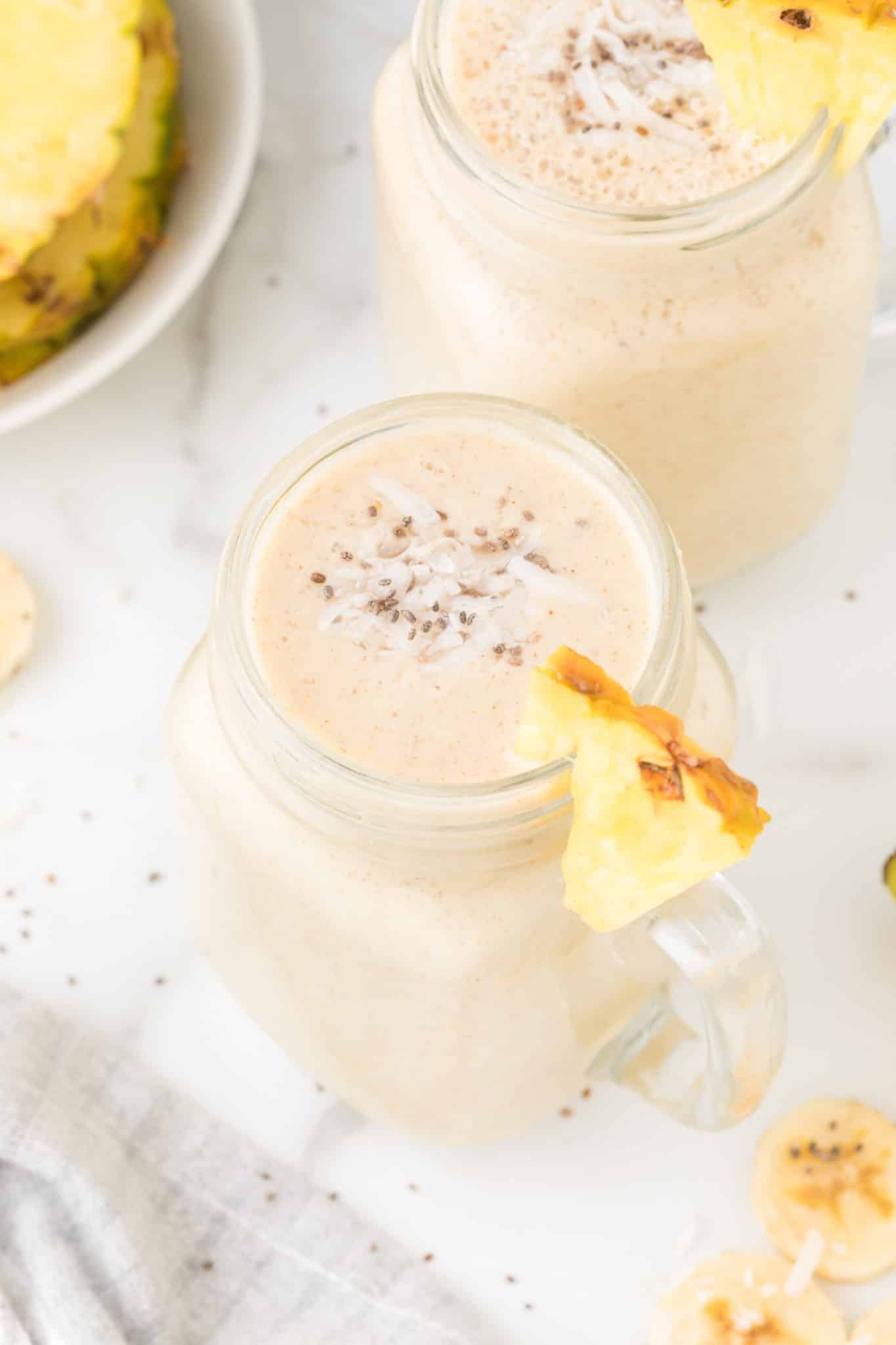 pineapple banana smoothies served in two glasses.