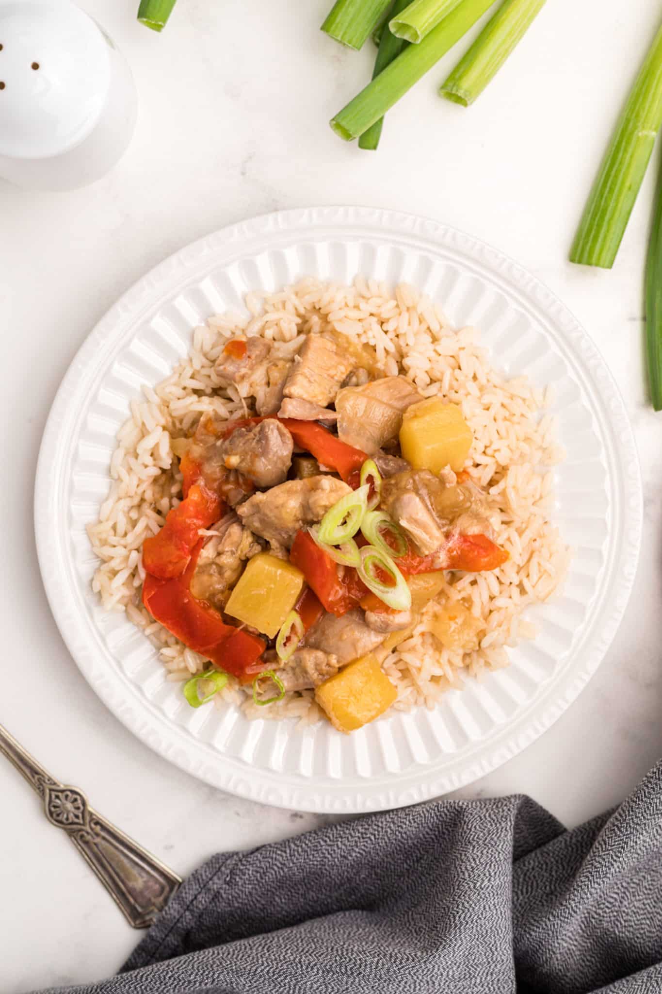 plate of pineapple chicken with veggies and steamed rice.