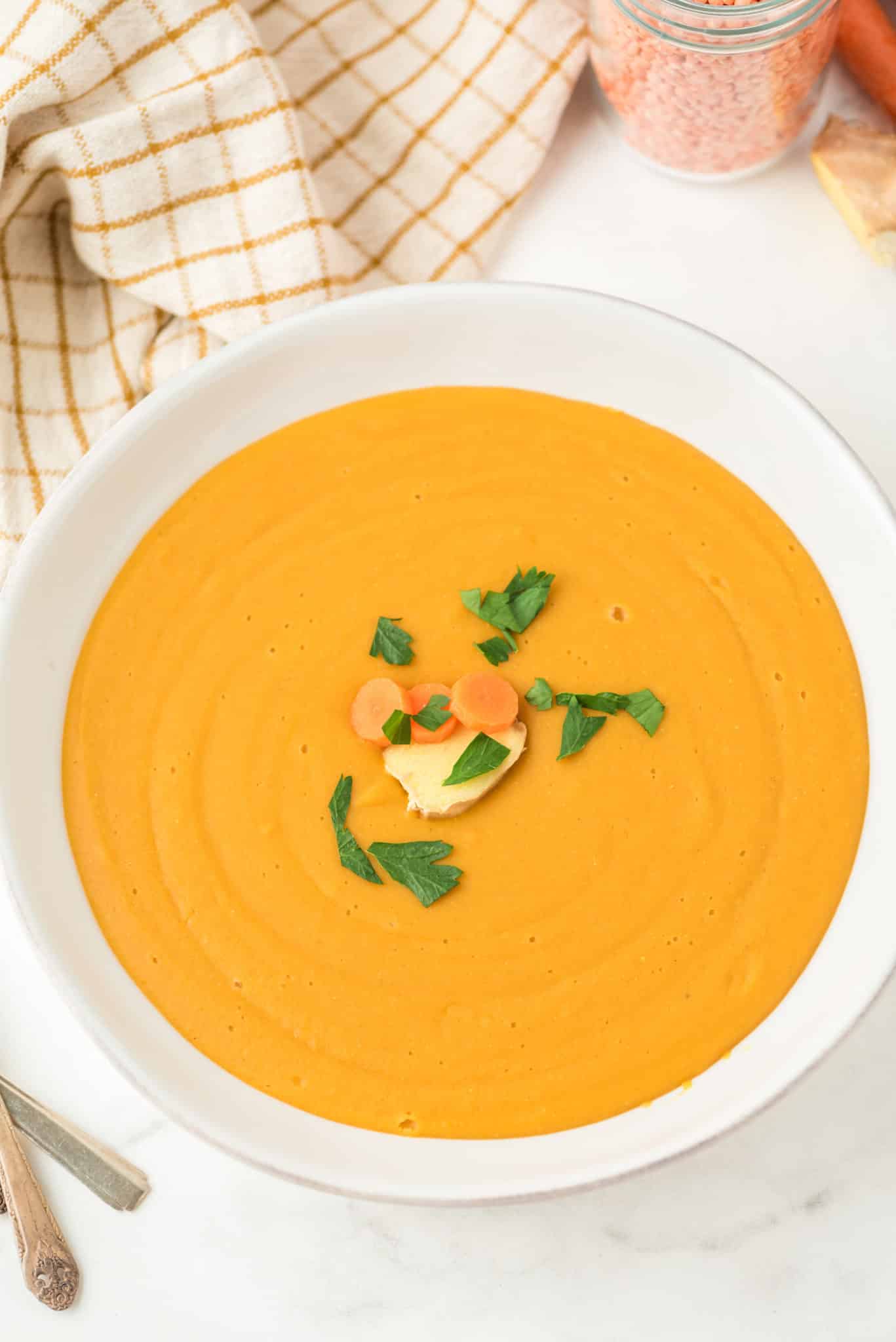 bowl of red lentil and carrot soup that has been blended to a puree.