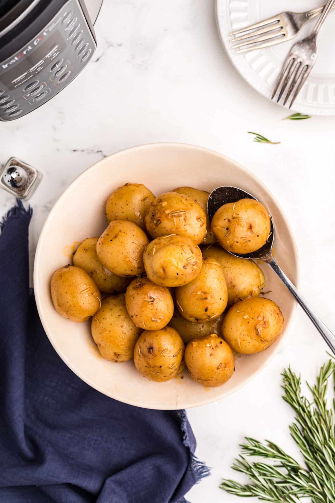 bowl of cooked potatoes with serving spoon.