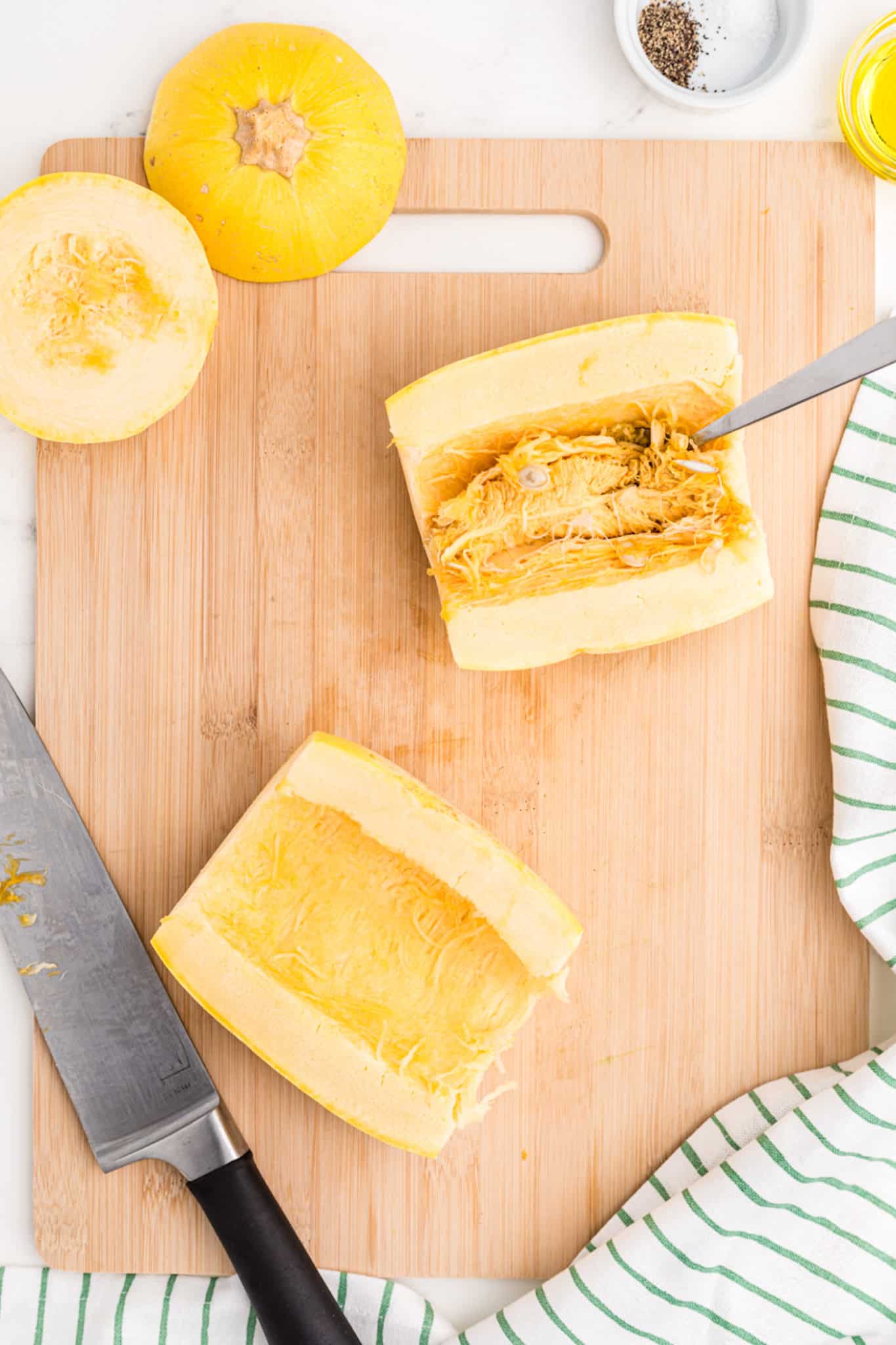 spaghetti squash cut in half on cutting board.