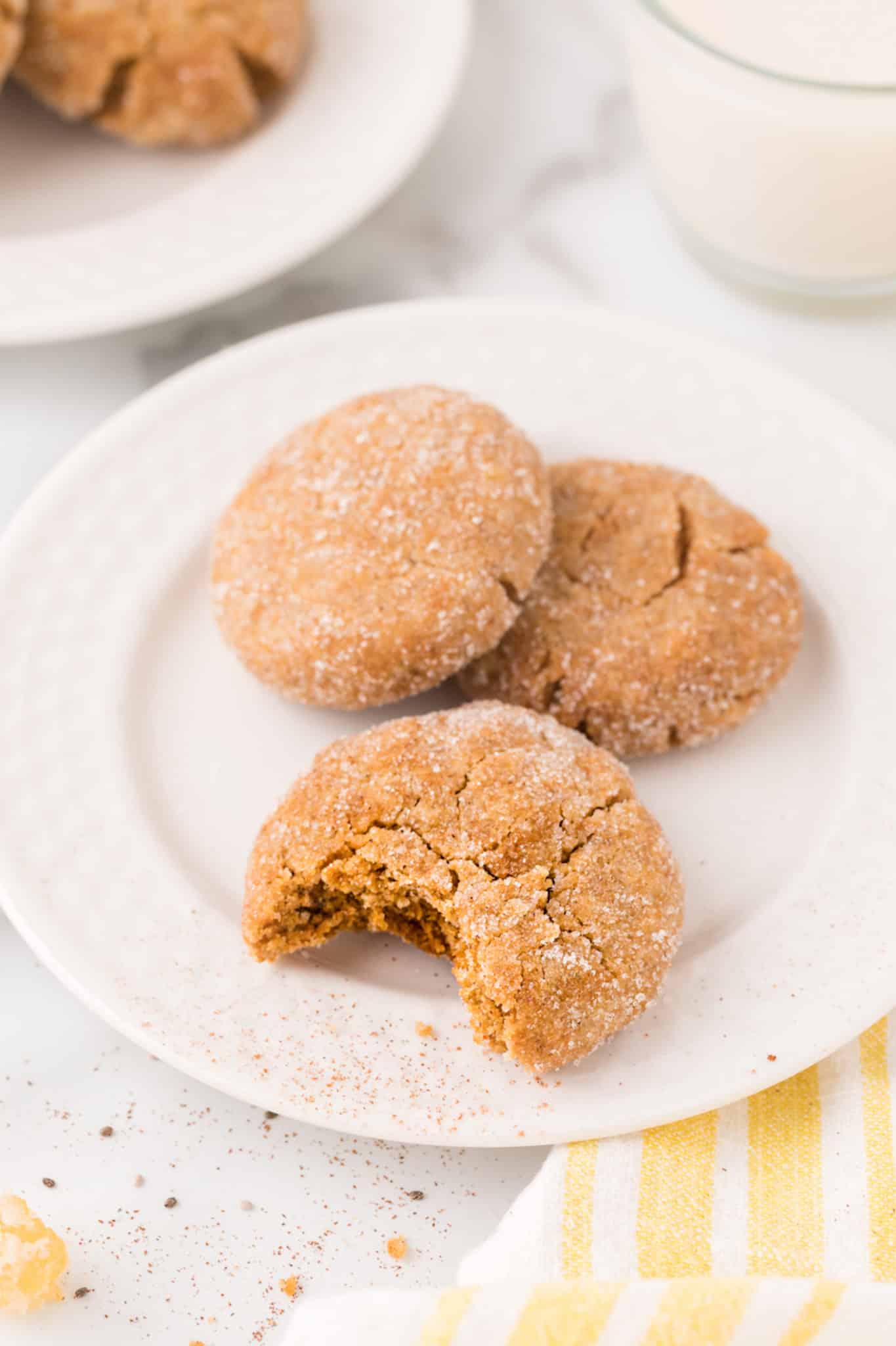 a bite of a vegan gingersnap cookie on a plate.