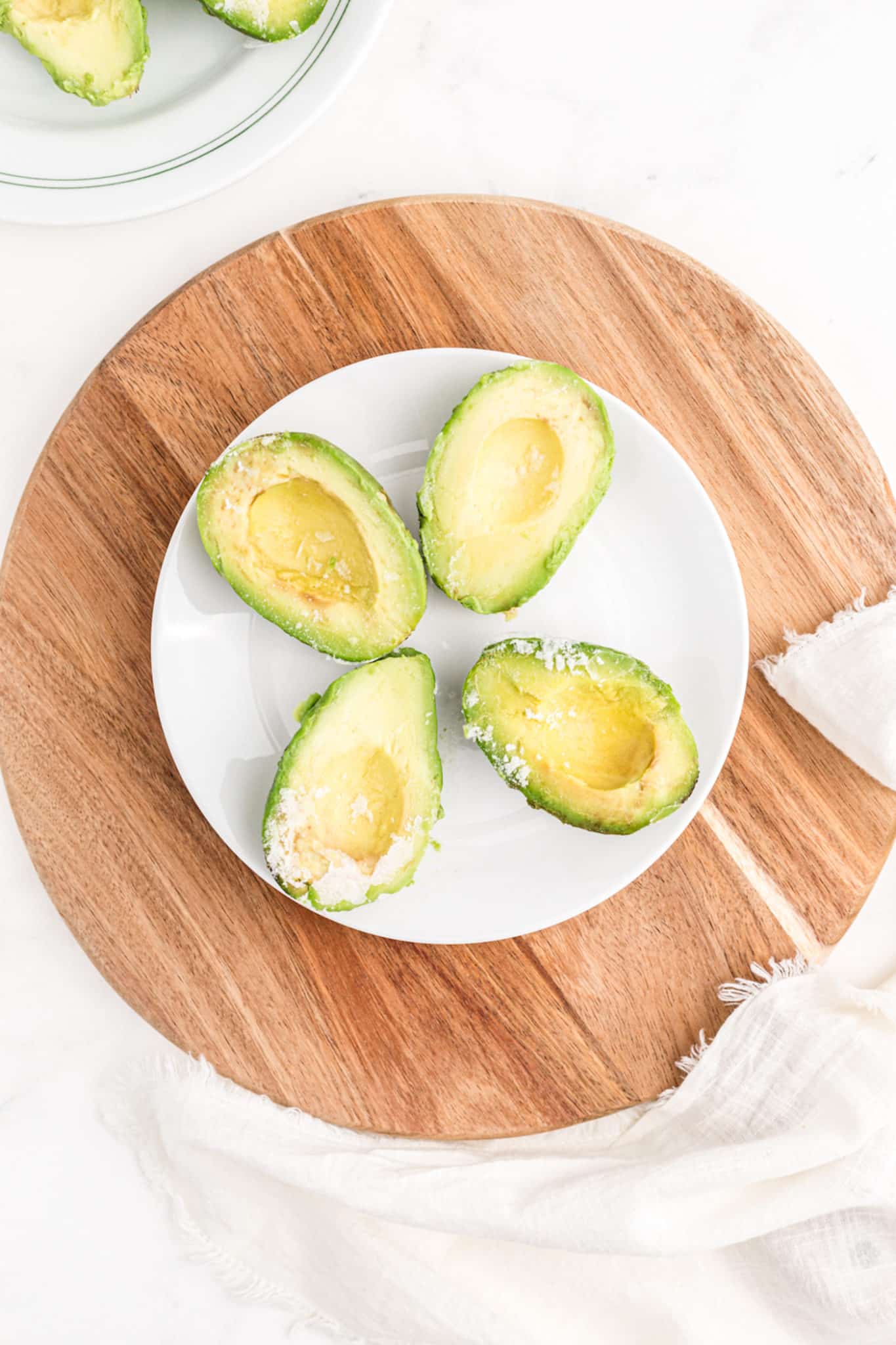 plate with four frozen avocado halves.