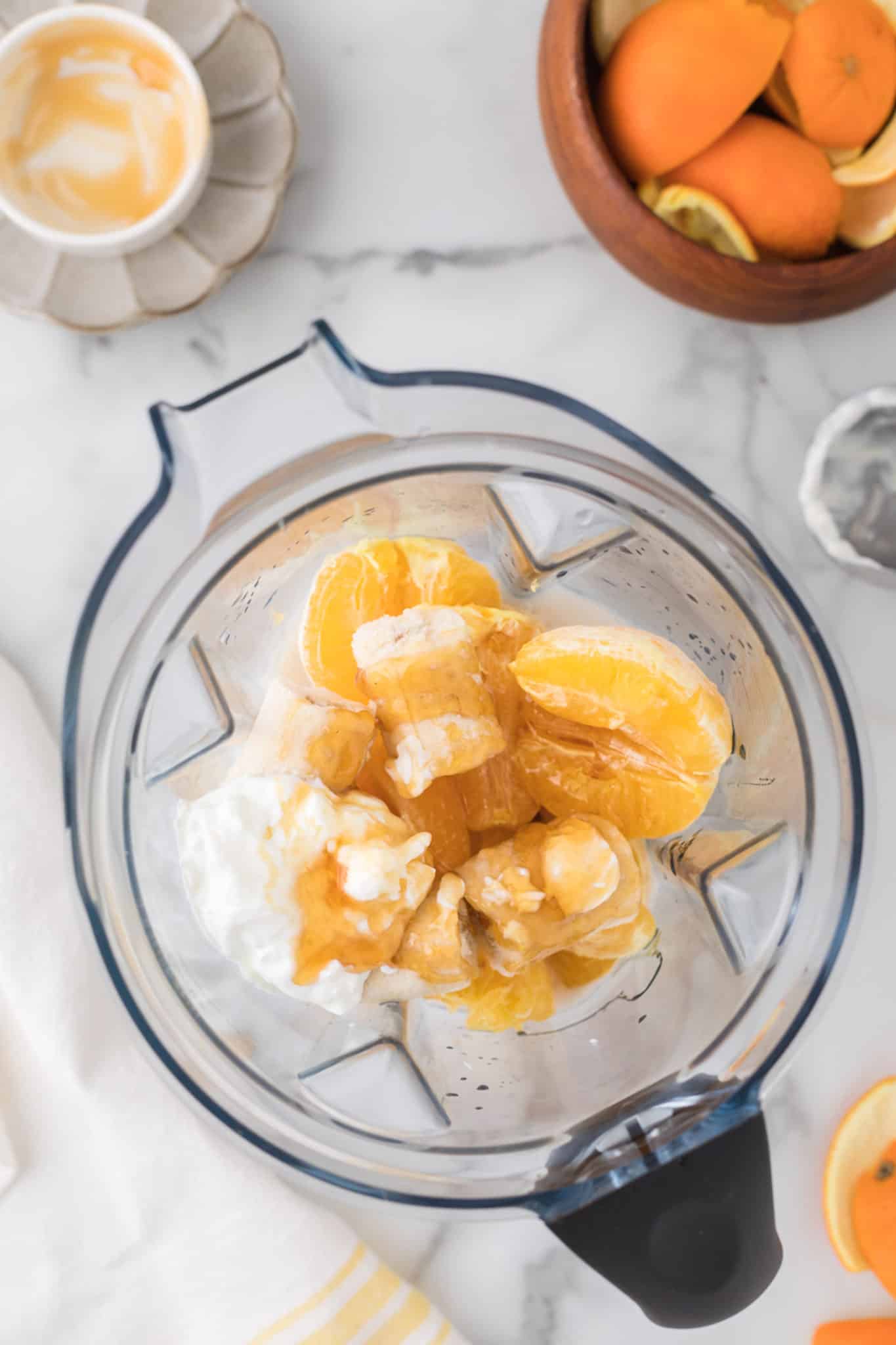 ingredients for banana orange smoothie inside blender.