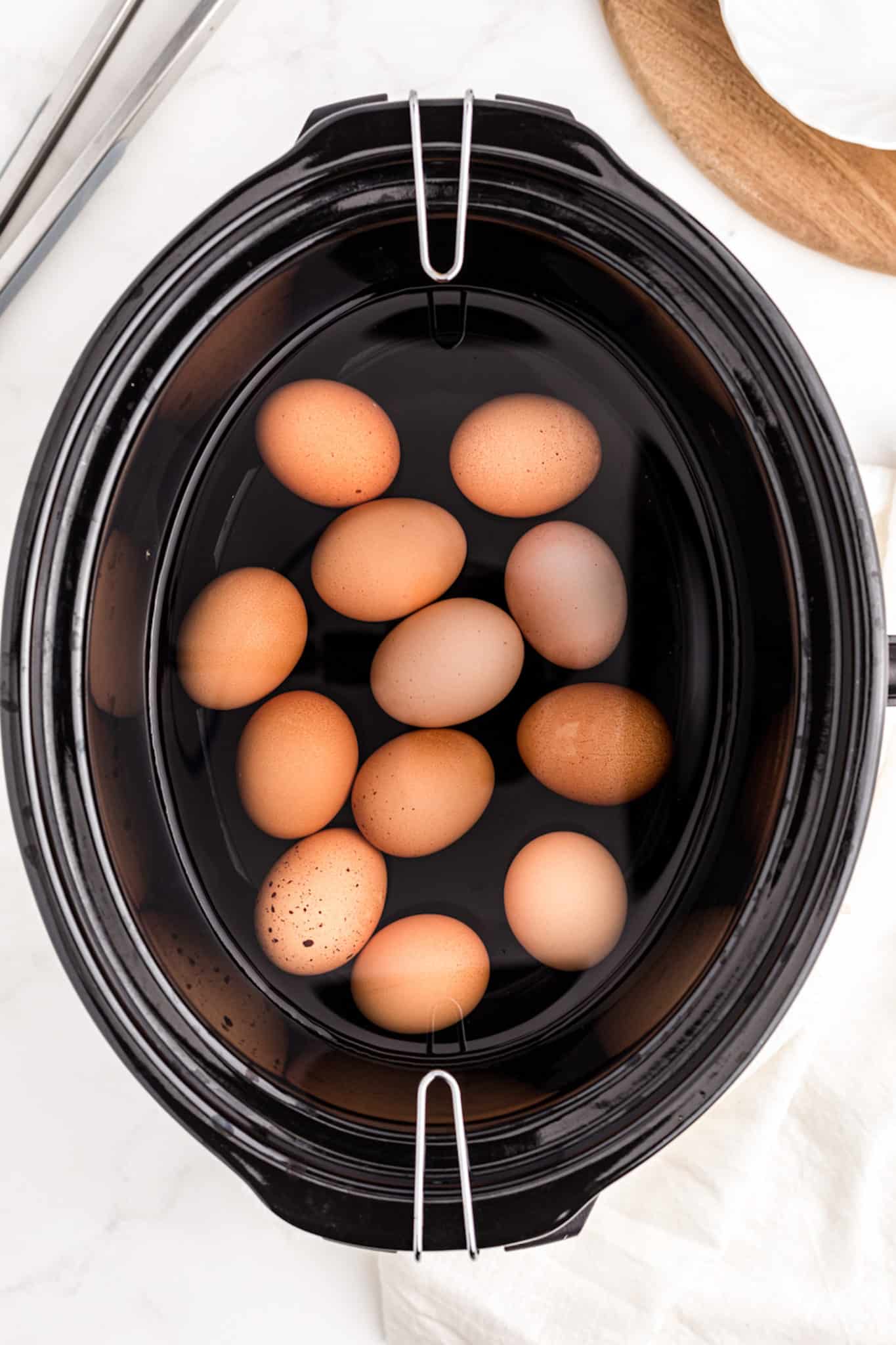 a crockpot with eggs and water.