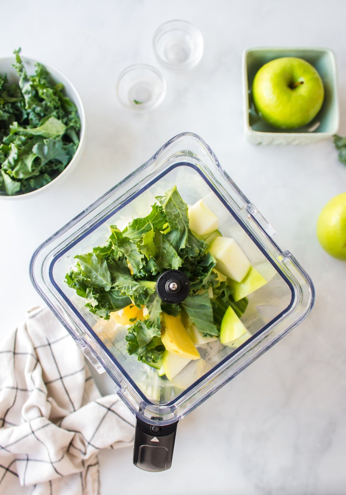 overhead shot of kale juice ingredients in blender pitcher.