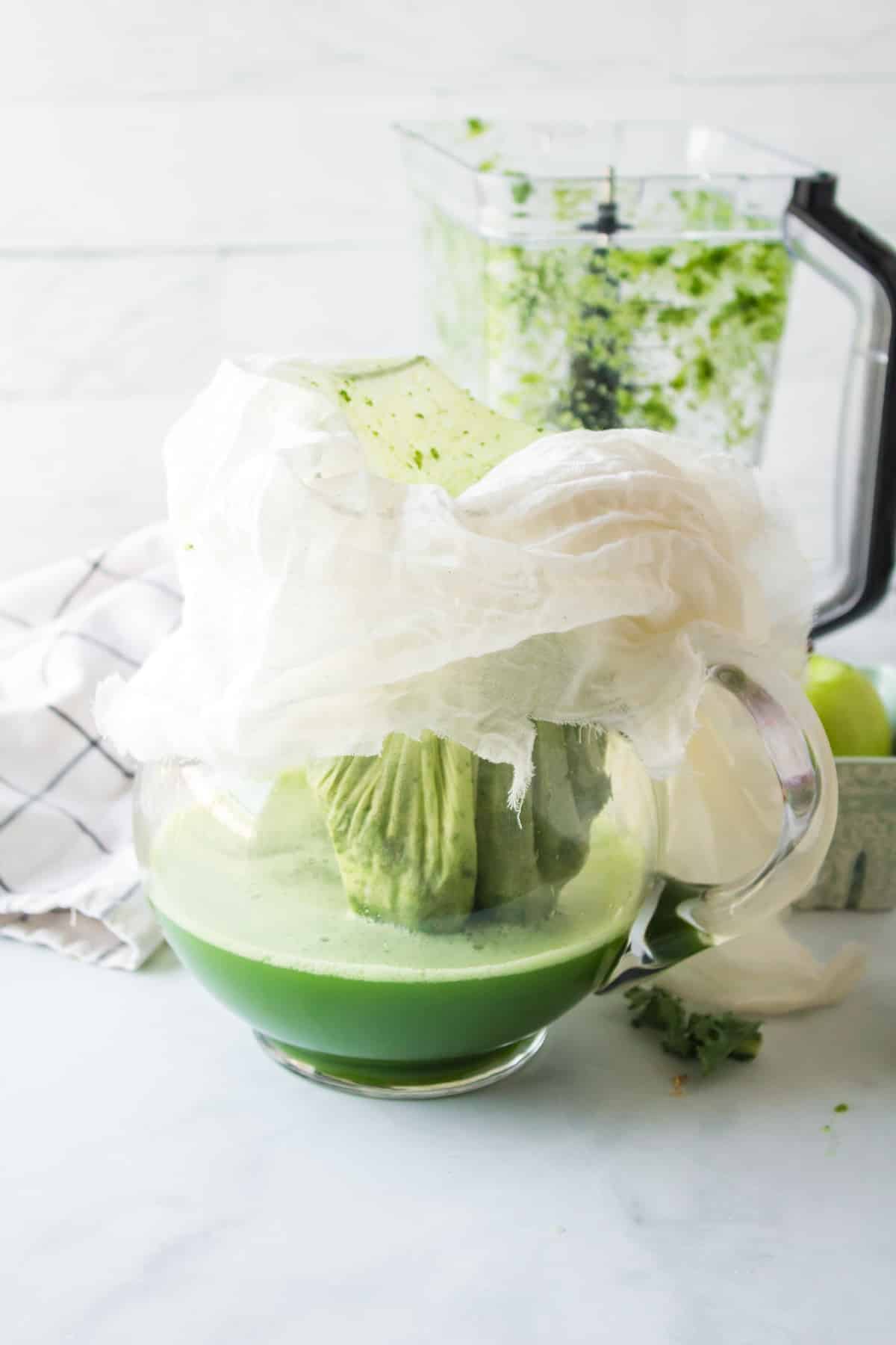 straining kale juice from pulp using a cheesecloth.