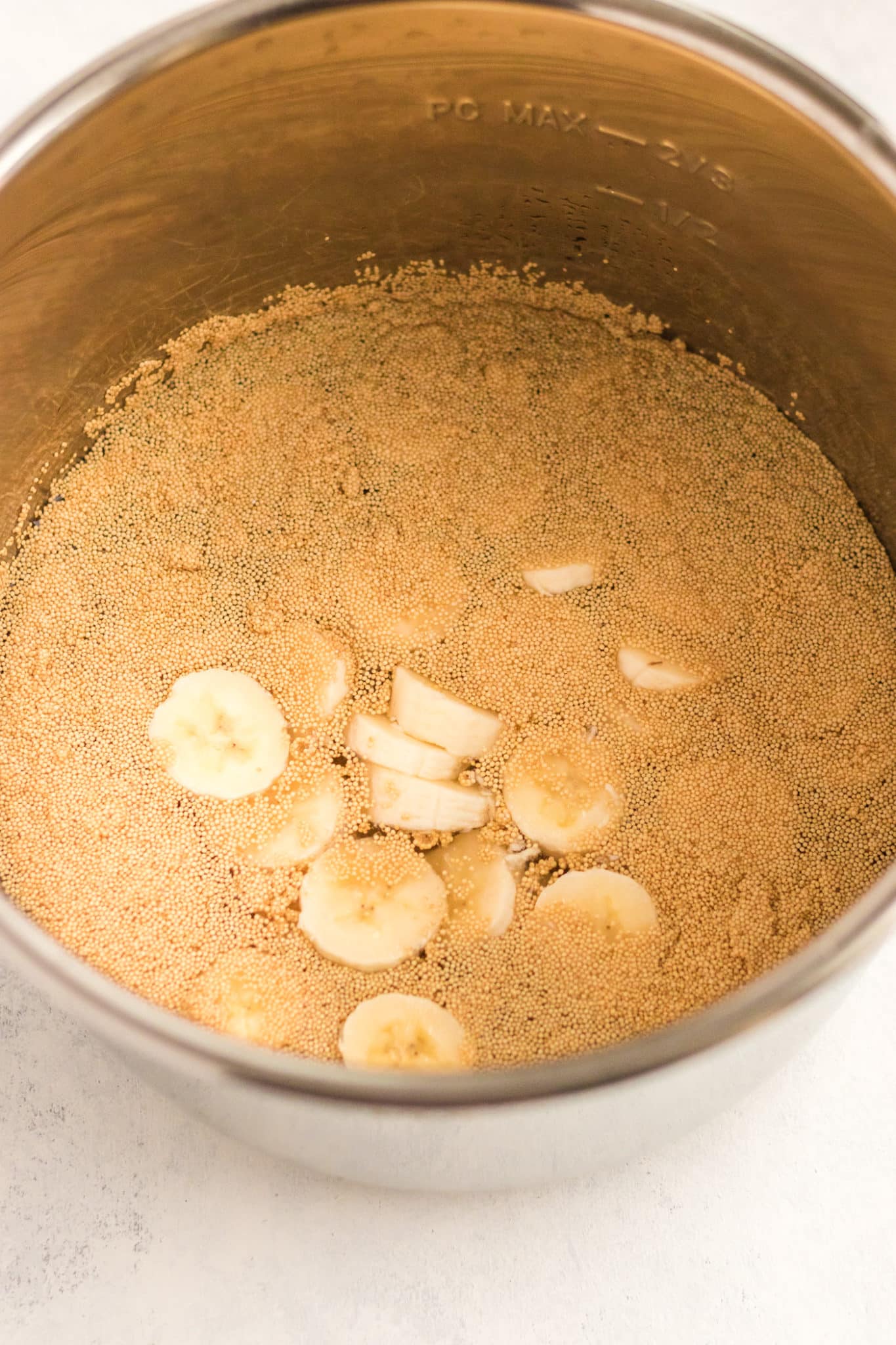 amaranth and sliced banana inside pressure cooker.