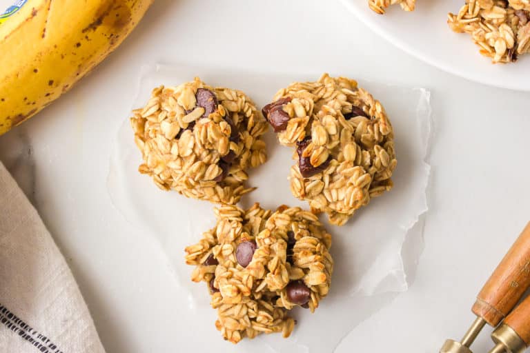 Trio of banana oat cookies on a slip of wax paper.