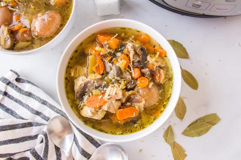 chicken soup with potatoes served in white bowls.