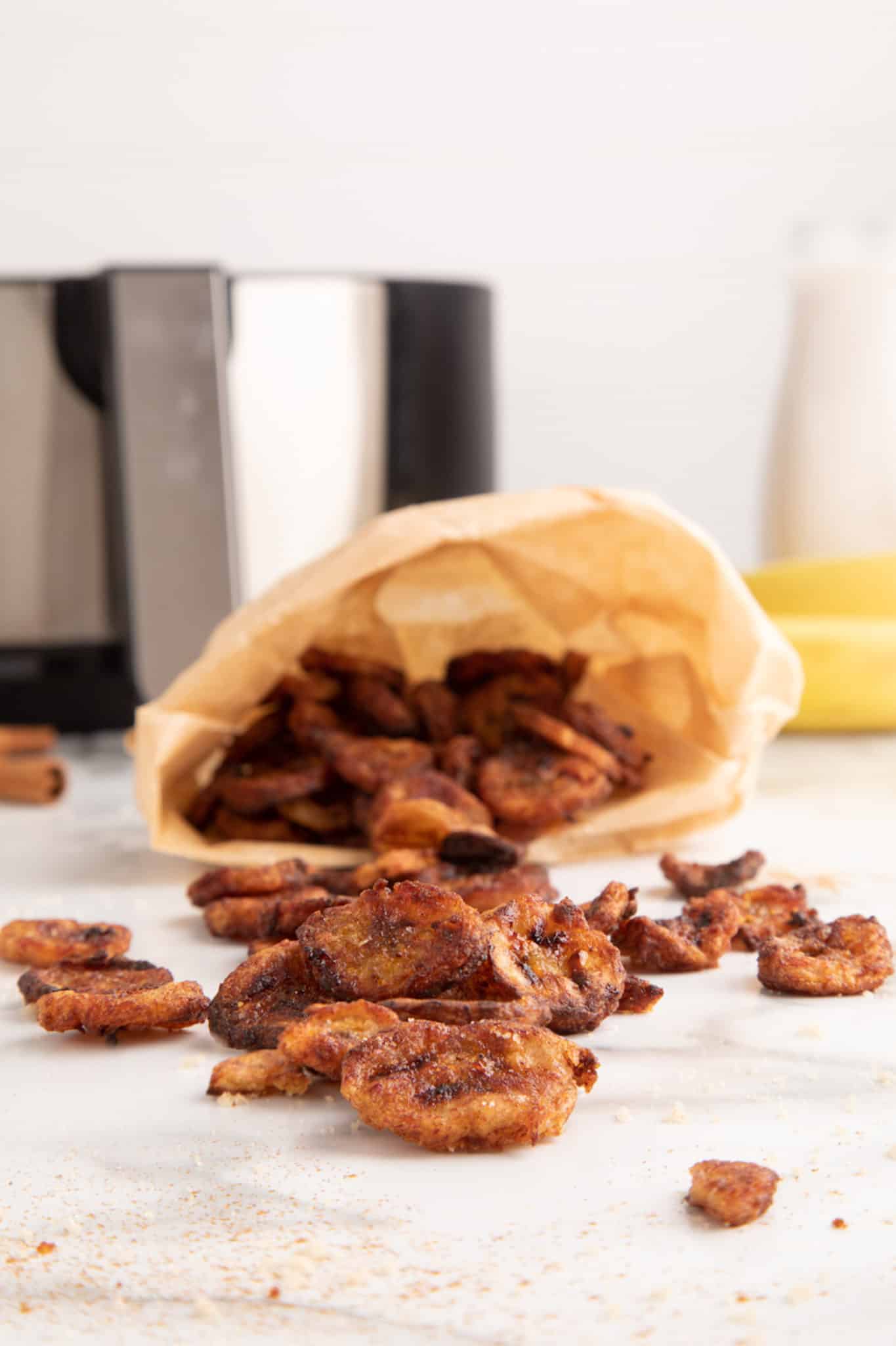 bag filled with banana chips laying on side on countertop.