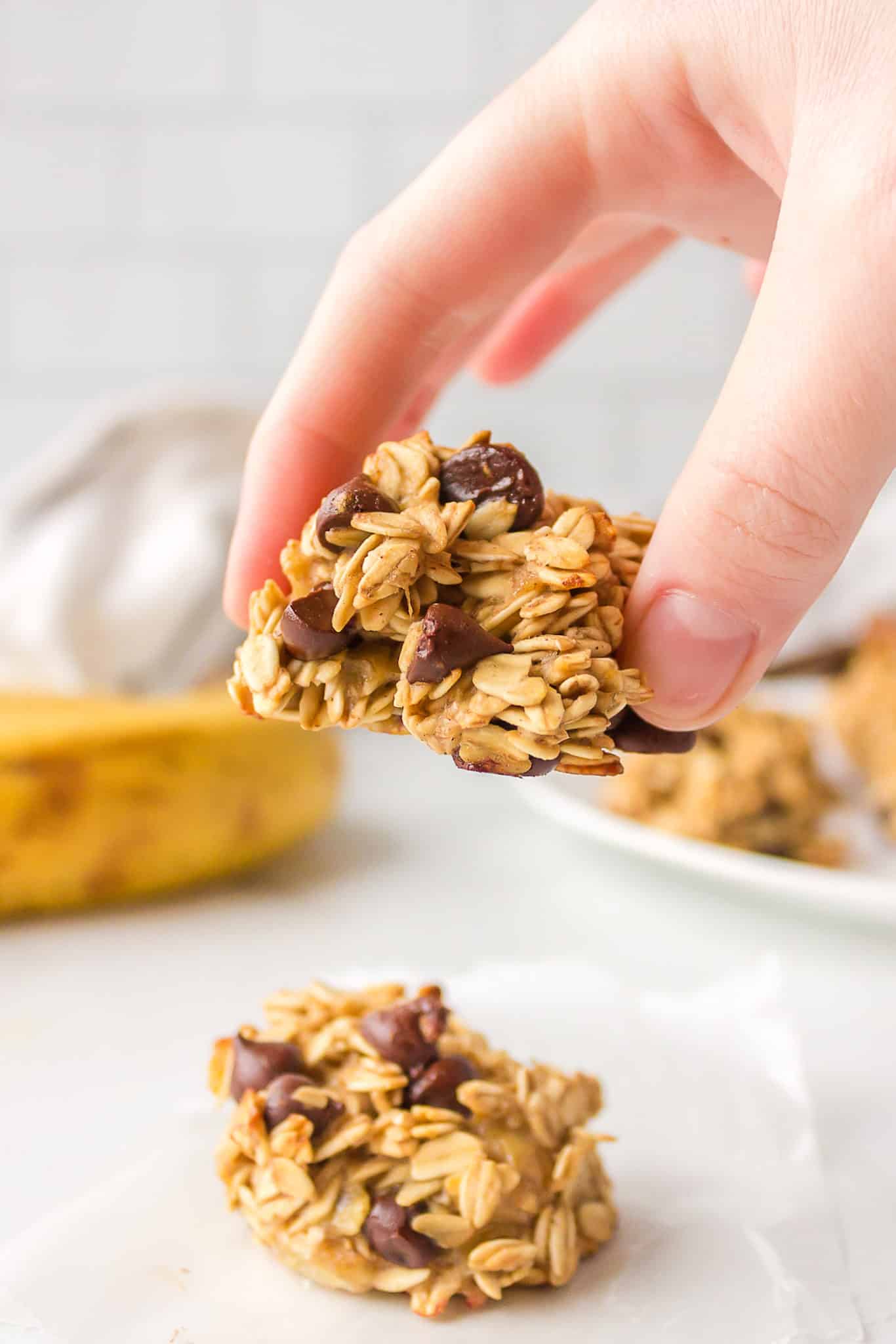 A hand holding a vegan banana oatmeal cookie.