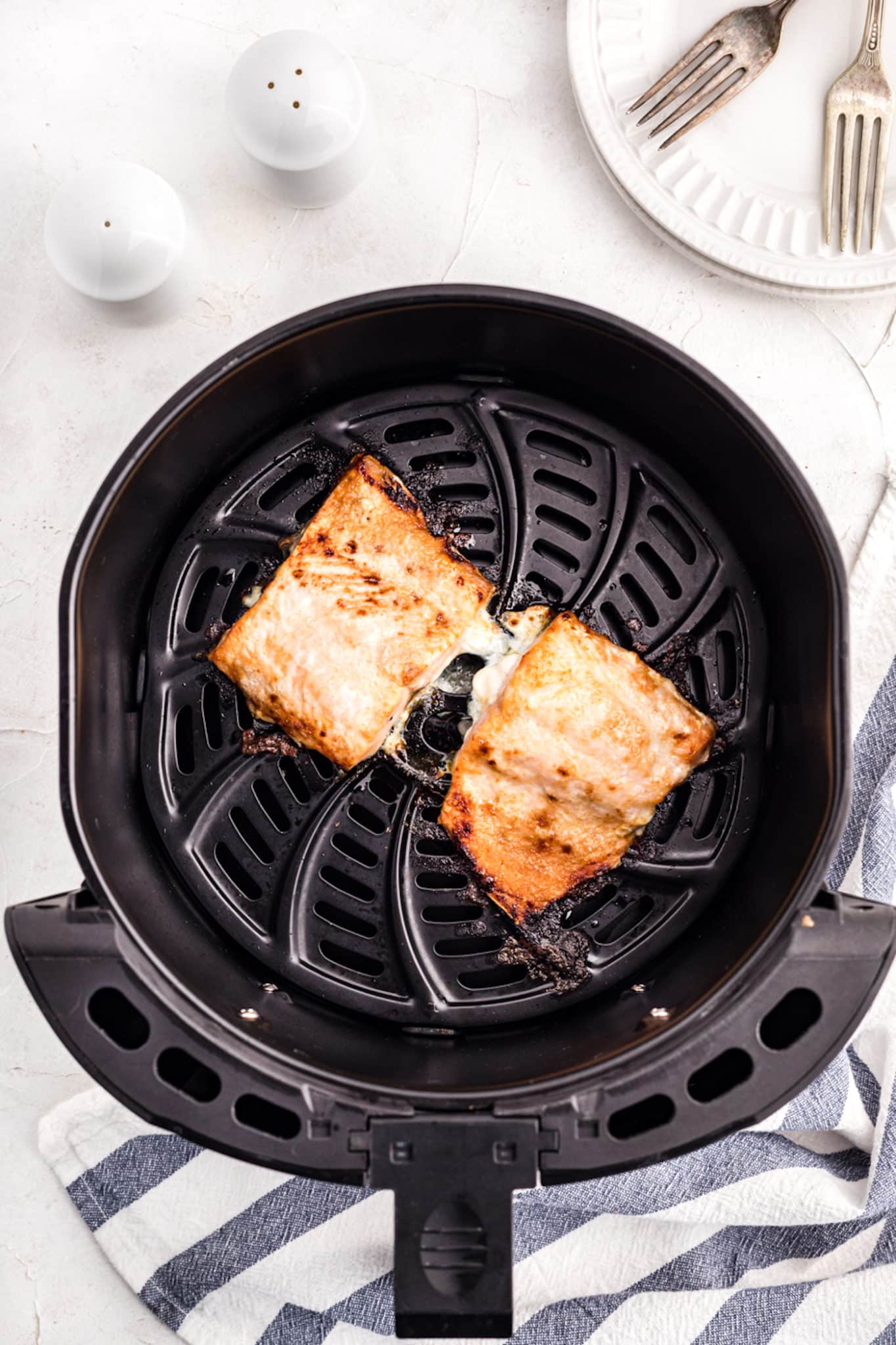 cooked frozen salmon fillets inside air fryer.