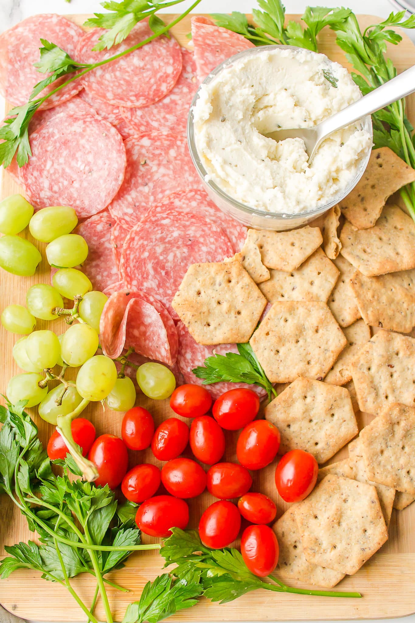 A dairy-free and gluten-free charcuterie board with grapes and tomatoes.