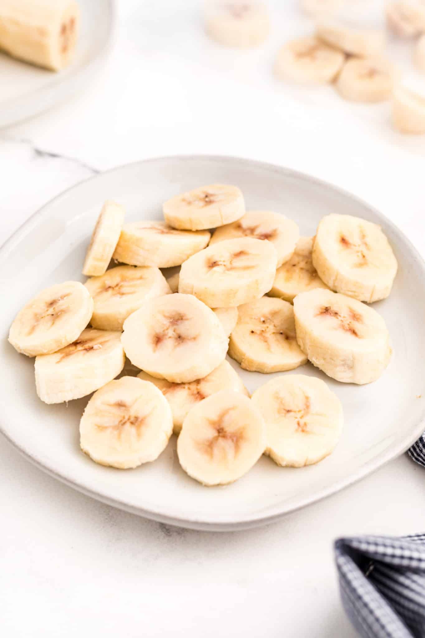 Frozen banana rounds on a small white plate.