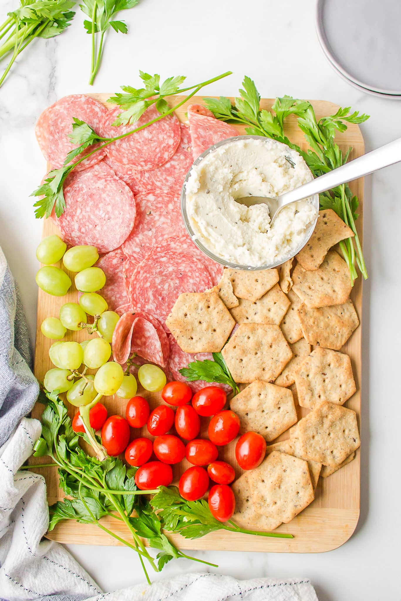 A dairy-free and gluten-free charcuterie board with grapes and tomatoes.