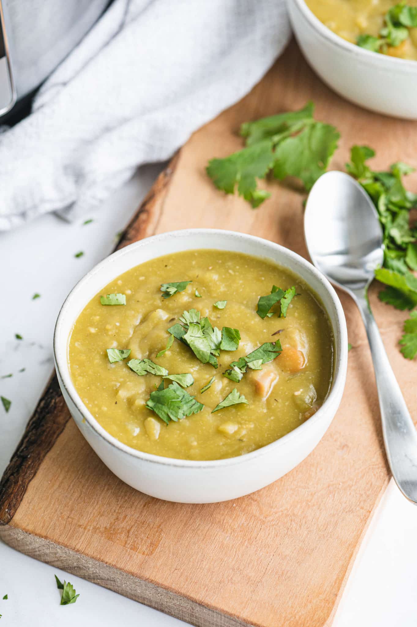 bowl of instant pot split pea soup on counter with spoon.