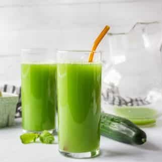 two tall glasses filled with green cucumber juice.