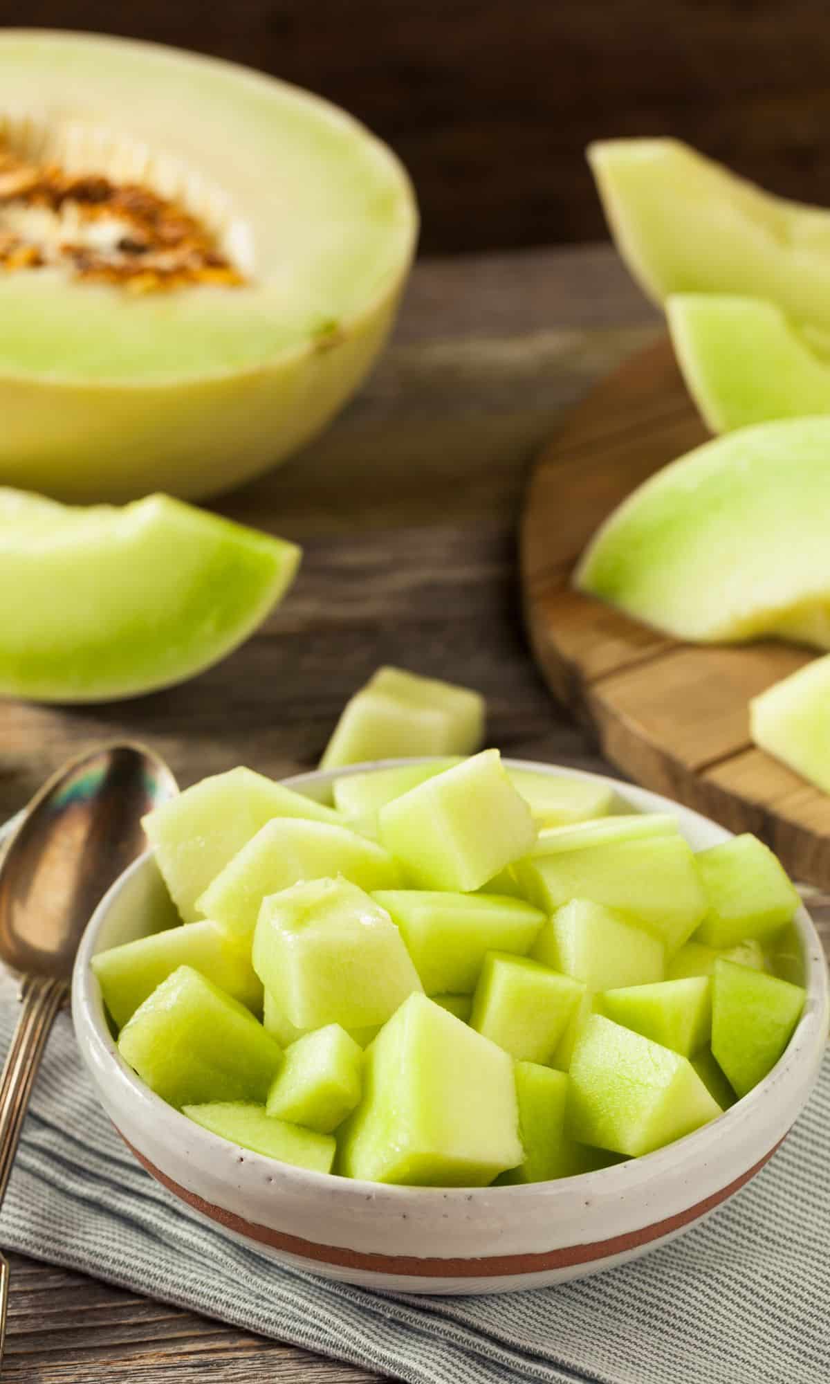 Green honeydew cut up in a bowl.