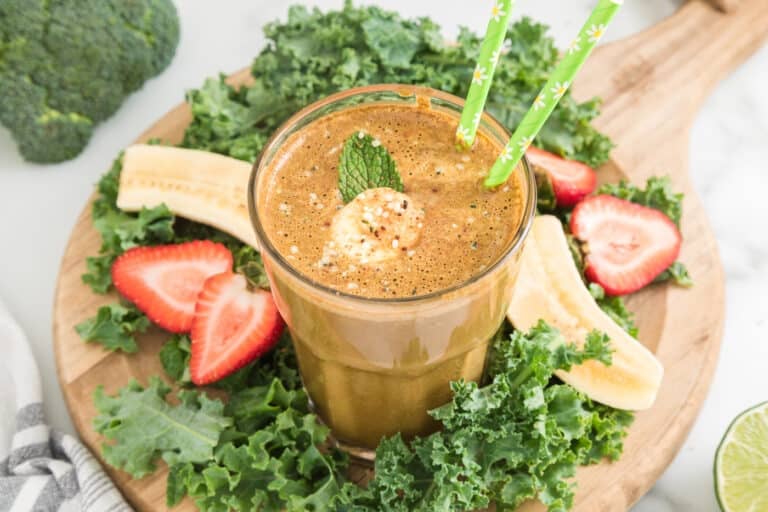 Cocoa green smoothie in a glass with two green straws.