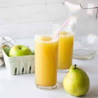 two glasses of fresh pear juice on table.