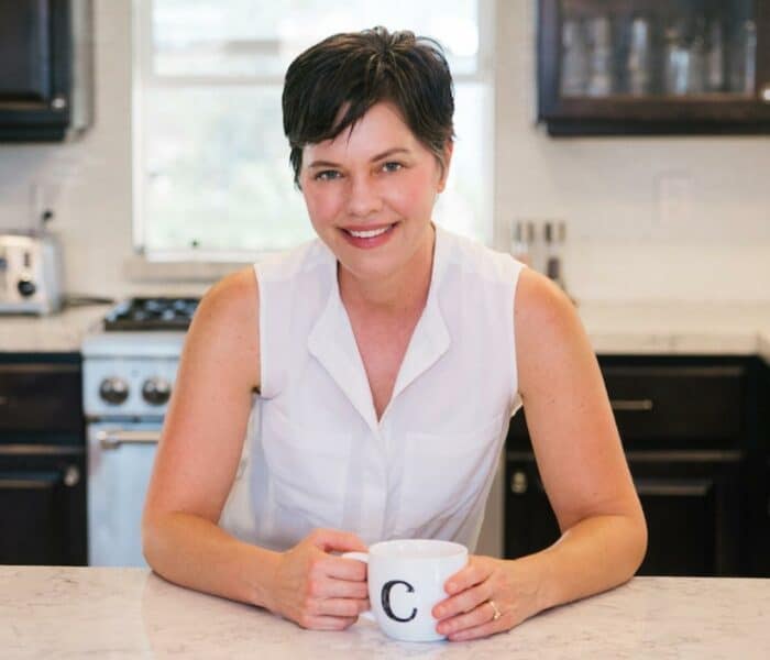 carrie with mug in kitchen.