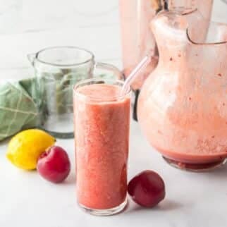 plum juice in glass with pitcher.