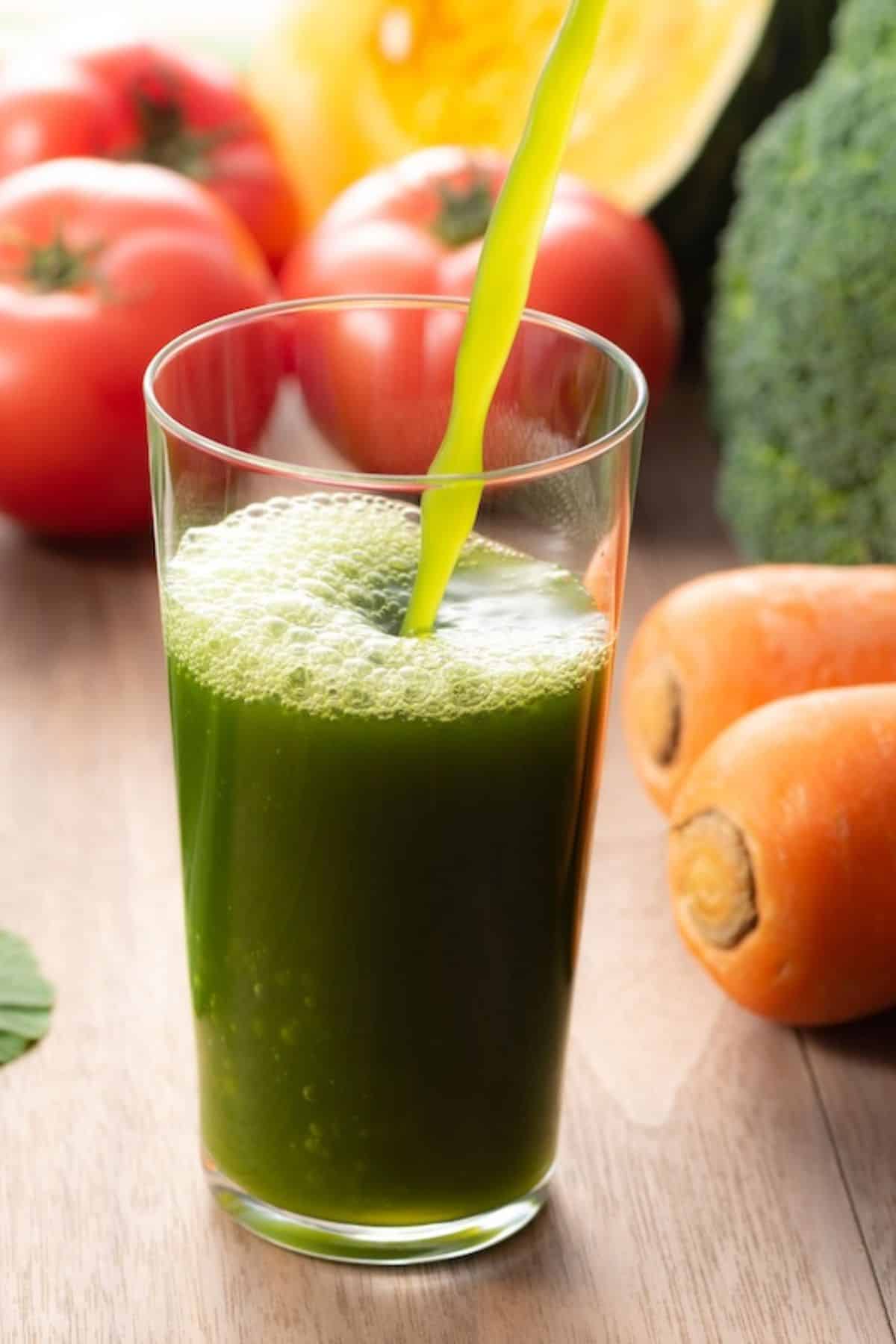 pouring green vegetable juice into glass