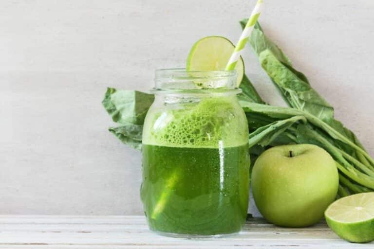 a glass of dandelion green juice with a straw.