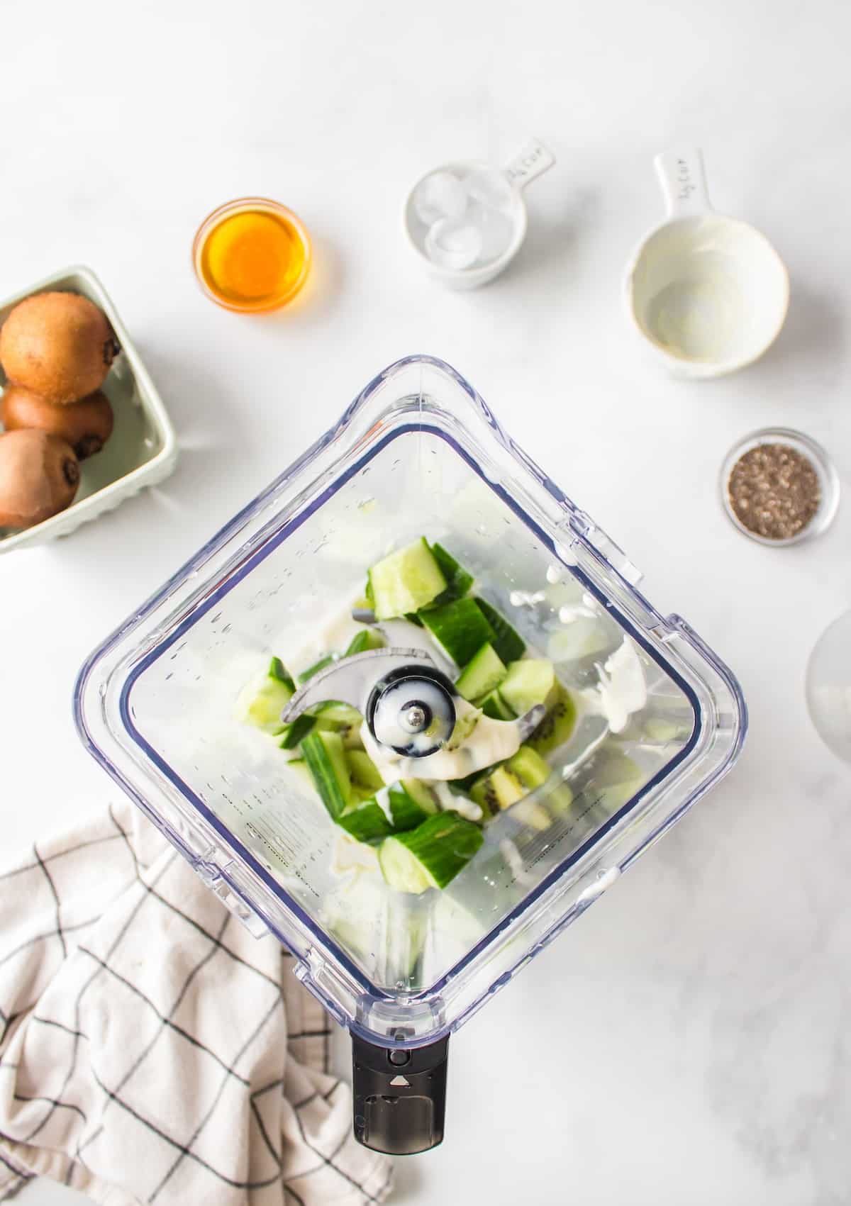 ingredients for a kiwi smoothie in a blender.