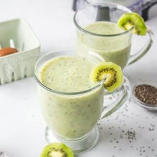 a glass of a kiwi smoothie with a straw.