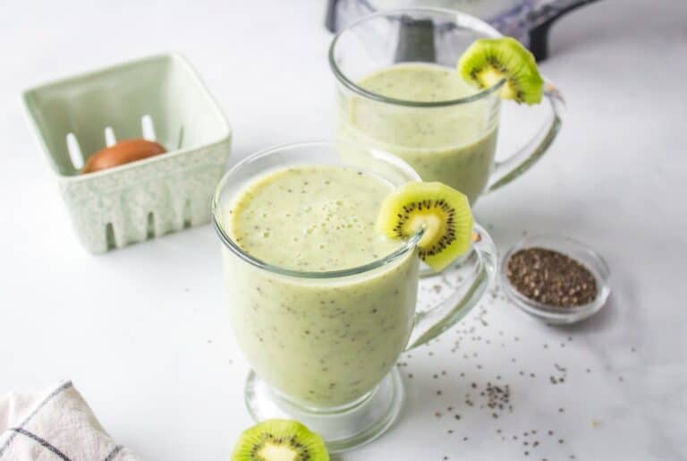 a glass of a kiwi smoothie with a straw.