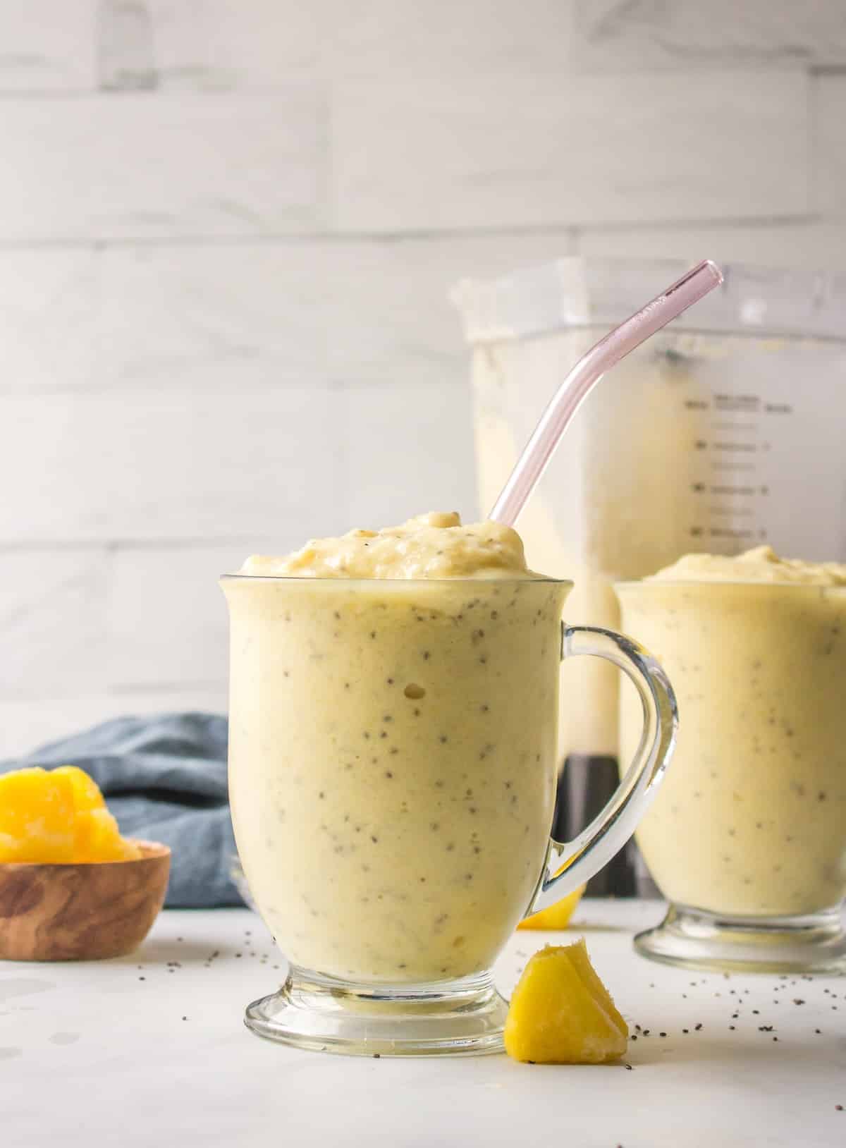 pineapple smoothie in glass with straw.